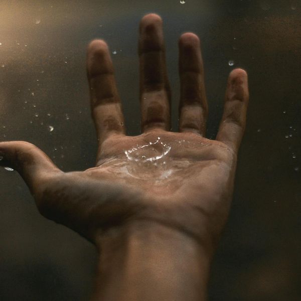 Person feeling energized and stretching outdoors with a serene background.